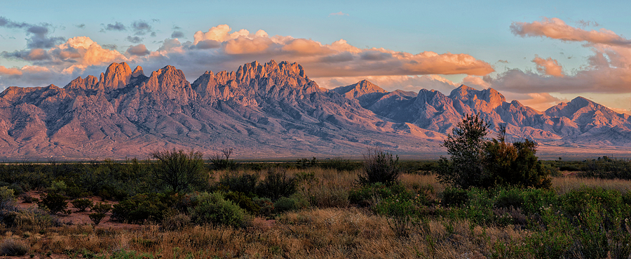 The Organ Mountains at sunset near Las Cruces, New Mexico — warm orange and pink tones over the rocky peaks